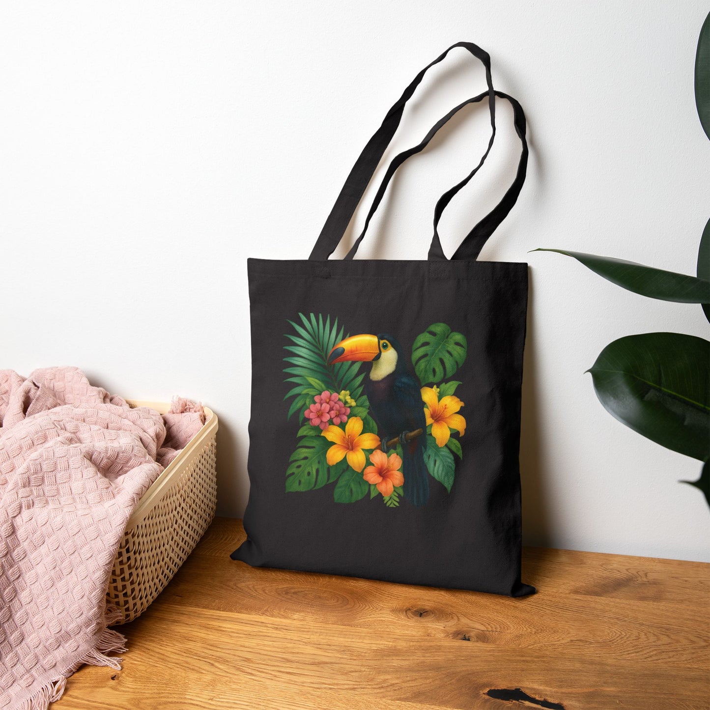 Black tote bag featuring a colorful toucan print bag with tropical flowers and leaves design