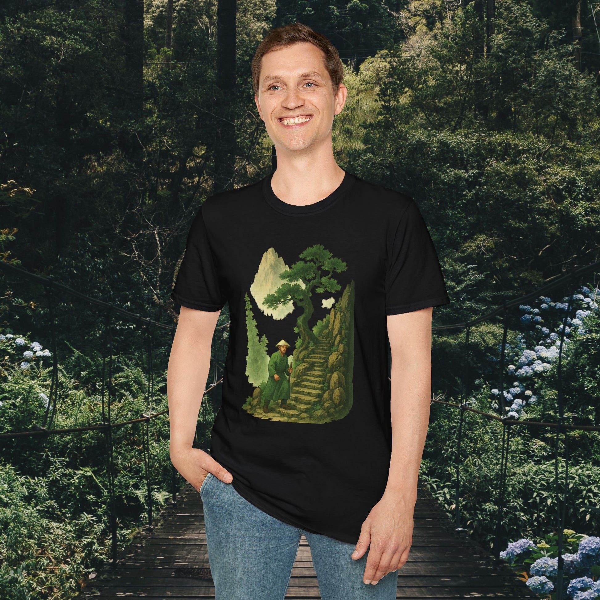 Black T-shirt with mountain print clothing design featuring a green landscape and stairs worn by smiling man
