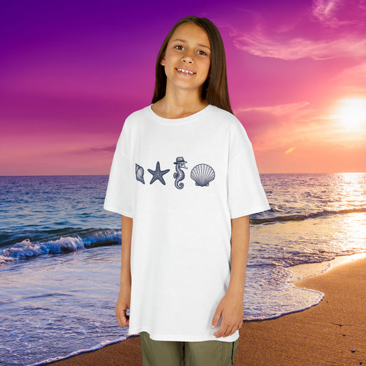 Kid wearing mashafrica style ocean themed tee with sea creature designs at the beach during sunset